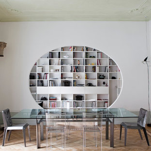 Idées déco pour une salle à manger contemporaine fermée avec un sol en bois clair, aucune cheminée, un sol multicolore et un mur blanc.