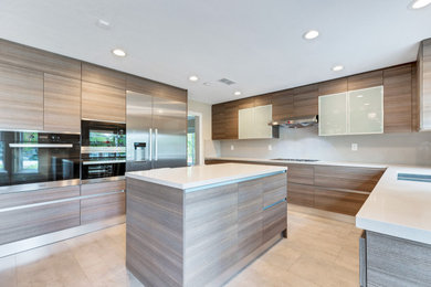 Example of a mid-sized minimalist u-shaped eat-in kitchen design in Los Angeles with flat-panel cabinets, light wood cabinets, stainless steel appliances and an island