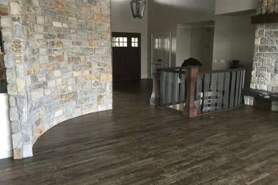 Example of a large transitional open concept medium tone wood floor family room design in Calgary with a standard fireplace, a stone fireplace, beige walls and no tv