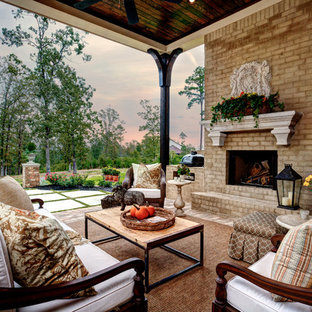 リトルロックの大きいトラディショナルスタイルのおしゃれな裏庭のテラス (レンガ敷き、張り出し屋根、屋外暖炉) の写真