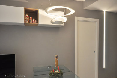 Стильный дизайн: открытая гостиная комната среднего размера в скандинавском стиле с серыми стенами, полом из керамогранита, телевизором на стене и коричневым полом - последний тренд