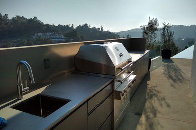 Example of a large trendy backyard concrete patio kitchen design in Los Angeles with a roof extension