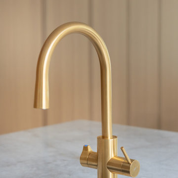Minimalist Brass Kitchen Faucet by Grohe on Honed Marble Countertop