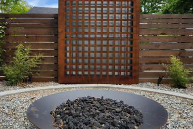 Cette image montre un petit jardin design avec une exposition ensoleillée, un gravier de granite et une clôture en bois.