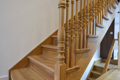 Imagen de escalera en L con escalones de madera, contrahuellas de madera y barandilla de madera