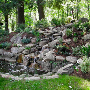 Large traditional backyard full sun formal garden in New York with natural stone pavers and with waterfall for spring.
