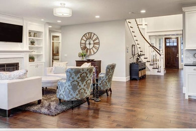 Example of a mid-sized transitional formal and open concept dark wood floor and brown floor living room design in Denver with white walls, a standard fireplace, a plaster fireplace and a wall-mounted tv