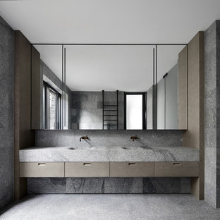 Immagine di una stanza da bagno minimalista con ante lisce, ante grigie, piastrelle grigie, pareti rosse, lavabo integrato, pavimento grigio e top grigio