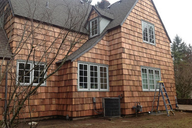 Imagen de fachada de casa marrón de tamaño medio de dos plantas con revestimiento de madera, tejado a cuatro aguas y tejado de teja de madera