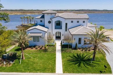 Inspiration for a white two-story stucco exterior home remodel in Jacksonville with a shingle roof and a gray roof