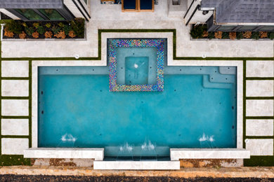 Large backyard stone and rectangular hot tub photo in Dallas