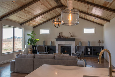 Example of a mid-sized farmhouse open concept medium tone wood floor and brown floor living room design in Oklahoma City with white walls, a standard fireplace, a tile fireplace and a wall-mounted tv