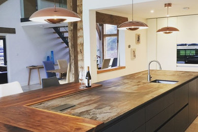 Design ideas for a contemporary kitchen in Buckinghamshire with a single-bowl sink, flat-panel cabinets, blue cabinets, engineered stone countertops, stainless steel appliances, travertine flooring, grey floors and multicoloured worktops.