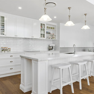 Inspiration for a large traditional galley kitchen pantry in Gold Coast - Tweed with an undermount sink, shaker cabinets, white cabinets, quartz benchtops, white splashback, subway tile splashback, stainless steel appliances, linoleum floors, with island, brown floor and yellow benchtop.