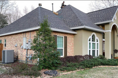 Diseño de fachada de casa beige y gris clásica grande de una planta con revestimiento de ladrillo, tejado a cuatro aguas, tejado de teja de madera y teja