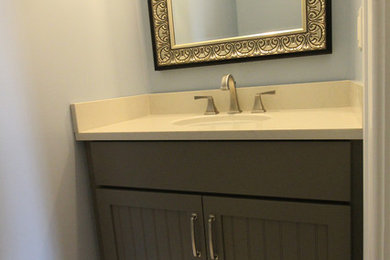Design ideas for a small transitional powder room in Detroit with shaker cabinets, grey cabinets, a two-piece toilet, blue walls, porcelain floors, an undermount sink, engineered quartz benchtops, white floor and beige benchtops.