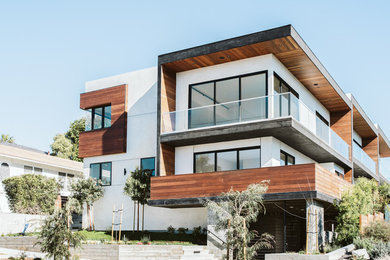 Large contemporary white three-story wood exterior home idea in Los Angeles with a mixed material roof