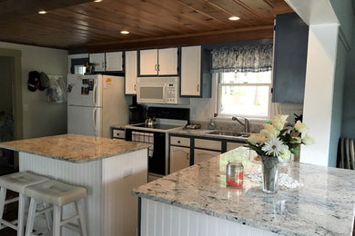 Enclosed kitchen - large traditional l-shaped dark wood floor and brown floor enclosed kitchen idea in Providence with a double-bowl sink, granite countertops, stone slab backsplash, stainless steel appliances, an island, recessed-panel cabinets, white cabinets and white countertops