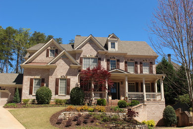Large traditional red two-story brick exterior home idea in Atlanta with a shingle roof
