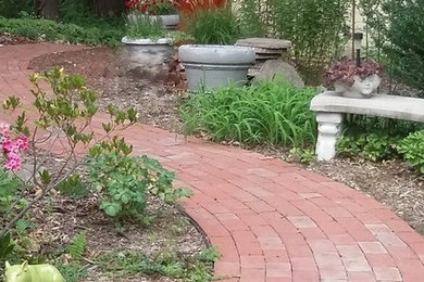 Design ideas for a mid-sized traditional partial sun backyard brick garden path in New York.