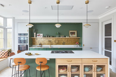 This is an example of a large scandinavian galley eat-in kitchen in London with an undermount sink, flat-panel cabinets, green cabinets, quartzite benchtops, metallic splashback, metal splashback, panelled appliances, light hardwood floors, with island, beige floor, white benchtop and wood.