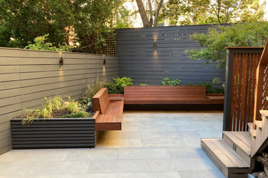 Photo of a mid-century modern shade backyard stone and wood fence landscaping in Toronto for fall.
