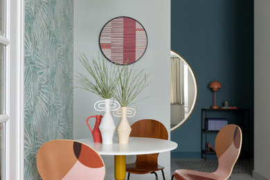Imagen de comedor contemporáneo con paredes azules, suelo de madera en tonos medios y papel pintado