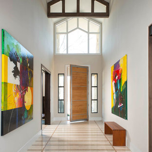 Пример оригинального дизайна интерьера: большая входная дверь в современном стиле с бежевыми стенами, мраморным полом, одностворчатой входной дверью и входной дверью из светлого дерева