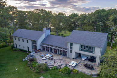 Large beach style gray two-story wood house exterior photo in New York with a shingle roof