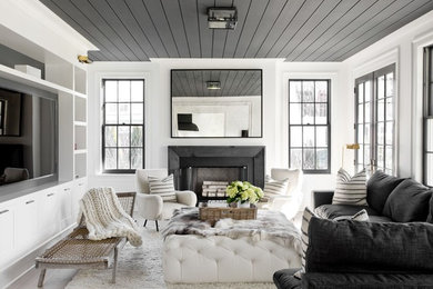 Mid-sized contemporary enclosed living room in New York with white walls, light hardwood floors, a standard fireplace, a metal fireplace surround, a built-in media wall and beige floor.