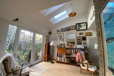 Large contemporary living room in Other with white walls, laminate floors, beige floors and a vaulted ceiling.