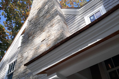 Modelo de fachada de casa gris costera extra grande de dos plantas con revestimientos combinados, tejado a dos aguas y teja
