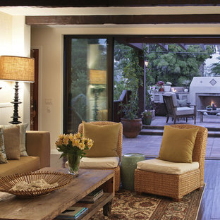 Photo of a large mediterranean open plan living room in Orange County with beige walls, lino flooring, a standard fireplace, a plastered fireplace surround and brown floors.