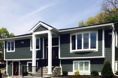 Imagen de fachada gris clásica de tamaño medio de dos plantas con revestimiento de aglomerado de cemento