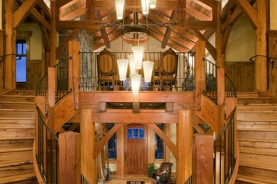 Staircase - large rustic wooden curved metal railing staircase idea in Other with wooden risers