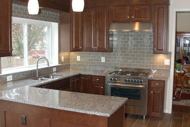 Example of a mid-sized transitional u-shaped eat-in kitchen design in DC Metro with an undermount sink, shaker cabinets, dark wood cabinets, granite countertops, gray backsplash, glass tile backsplash, stainless steel appliances and a peninsula