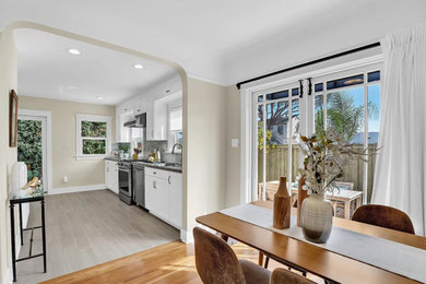 Mid-sized tuscan light wood floor and brown floor kitchen/dining room combo photo in San Diego with white walls