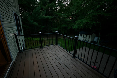 Modelo de terraza de tamaño medio en patio trasero con barandilla de metal