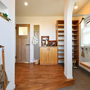 札幌のアジアンスタイルのおしゃれな玄関 (白い壁、無垢フローリング、茶色い床) の写真