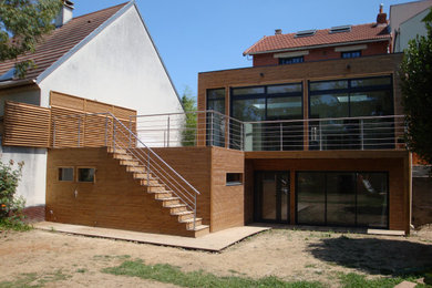 Ejemplo de fachada de casa bifamiliar marrón contemporánea de tamaño medio de dos plantas con revestimiento de madera, tejado plano, techo verde y tablilla