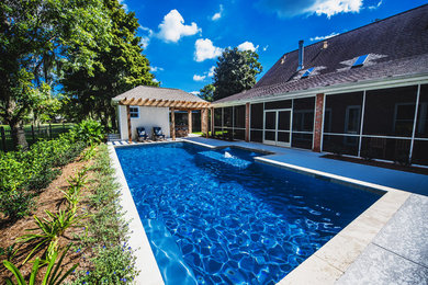 Pool fountain - large traditional backyard stone and custom-shaped pool fountain idea in New Orleans