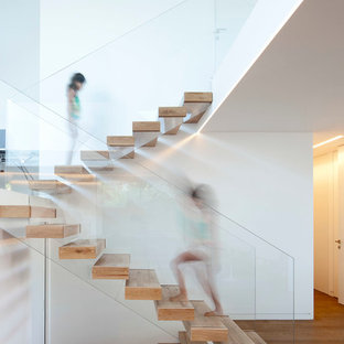 Ejemplo de escalera suspendida, minimalista, con barandilla de vidrio