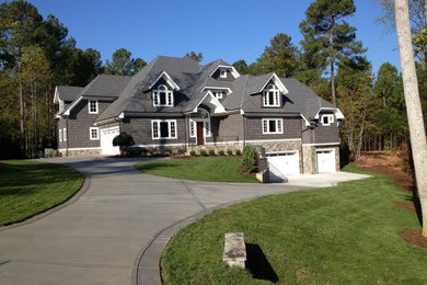 Huge elegant gray split-level mixed siding house exterior photo in Raleigh with a hip roof and a shingle roof