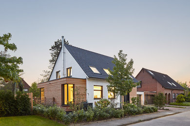 This is an example of a mid-sized modern one-storey brick white exterior in Dusseldorf with a gable roof.