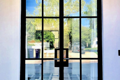 Inspiration for a large modern porcelain tile and multicolored floor entryway remodel in Oklahoma City with white walls and a black front door