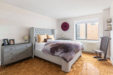 Modelo de dormitorio principal ecléctico de tamaño medio con paredes rosas, suelo de madera clara y suelo marrón