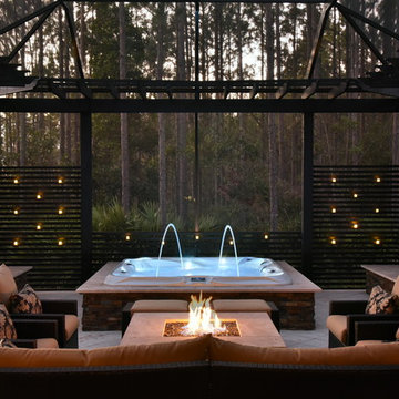 Screened area with sunken spa, fire pit and outdoor kitchen.