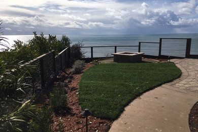Example of a backyard concrete paver patio design in Other with a fire pit