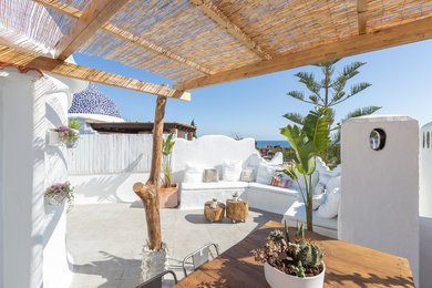 Ejemplo de terraza mediterránea de tamaño medio en azotea con jardín de macetas y pérgola
