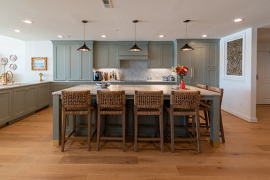 Transitional l-shaped medium tone wood floor and brown floor kitchen photo in Cincinnati with an undermount sink, shaker cabinets, gray cabinets, gray backsplash, paneled appliances, an island and gray countertops